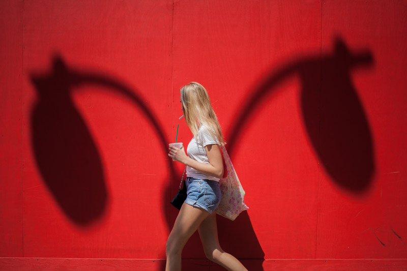 woman on street with red background