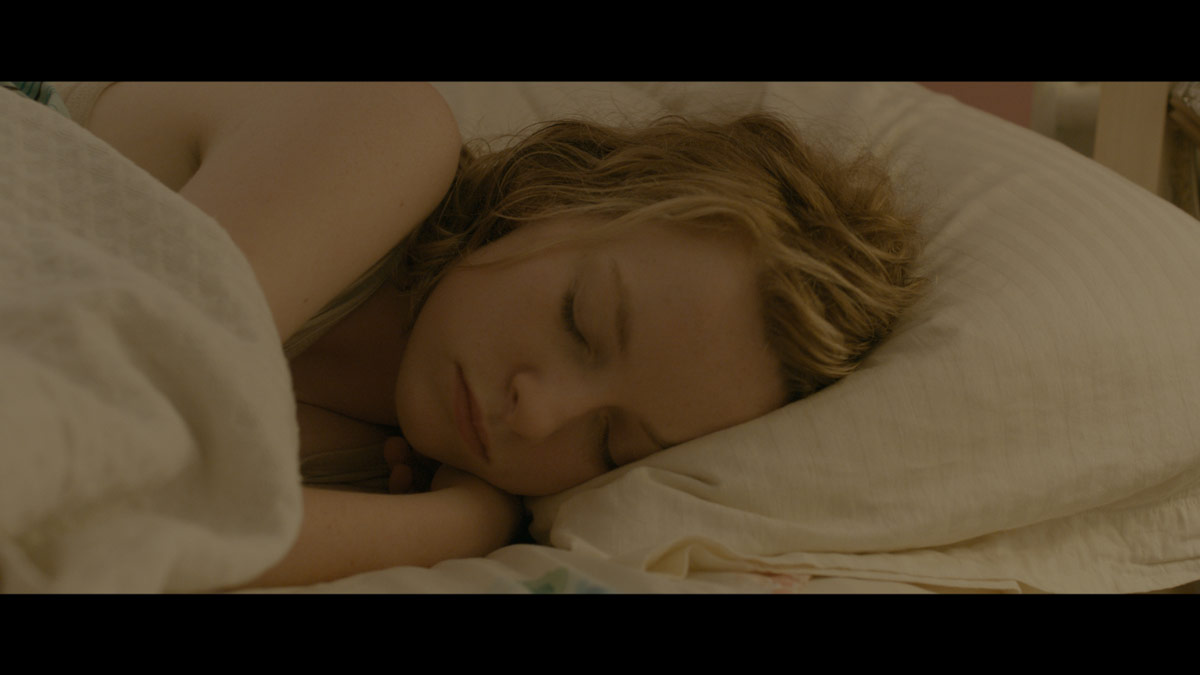 still from I Used To Be Darker: girl asleep in bed