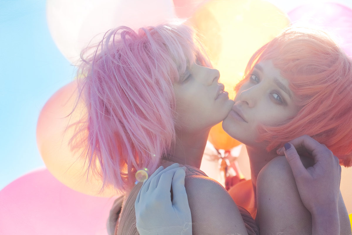 two beautiful young women with bright hair and balloons in the background