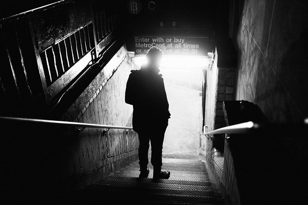 a young man walking down stairs to the subway