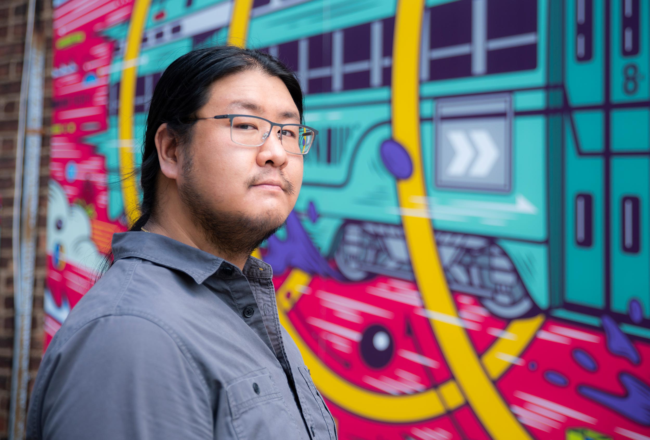 portrait of WONGFACE in front of "Where We're Going" mural in Lakewood, Ohio