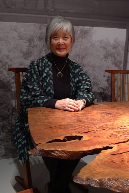 Mira Nakashima sitting at a table set created by Nakashima Woodworkers. (Photo provided by Nakashima Woodworkers)